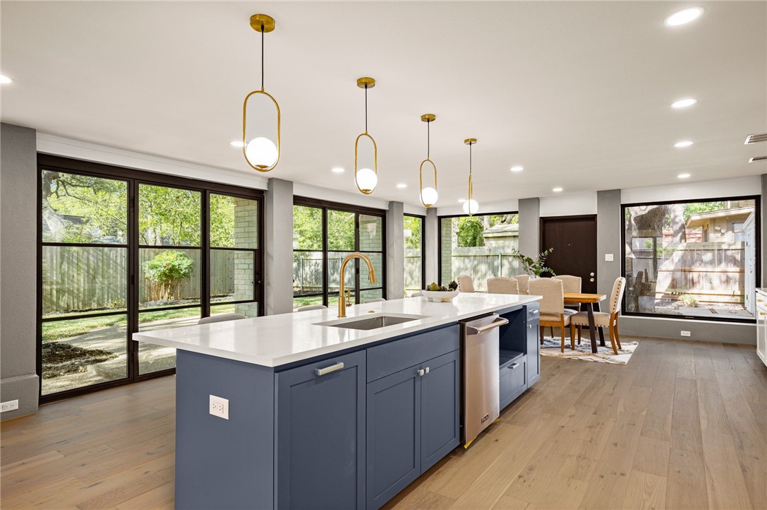 a large kitchen with kitchen island a large window a sink and cabinets