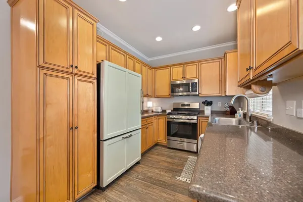 a kitchen with stainless steel appliances granite countertop a refrigerator stove and a sink