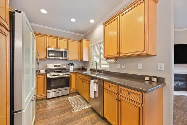 a kitchen with stainless steel appliances granite countertop a stove a sink and a refrigerator