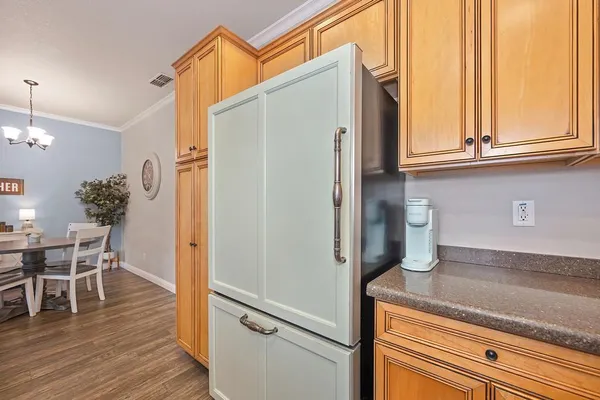a kitchen with stainless steel appliances granite countertop a refrigerator and a wooden cabinets