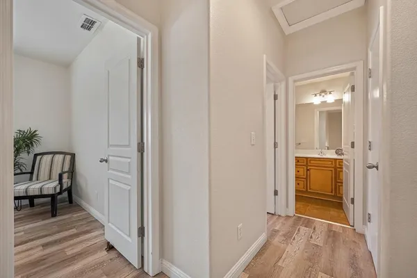 a view of a hallway with wooden floor and closet