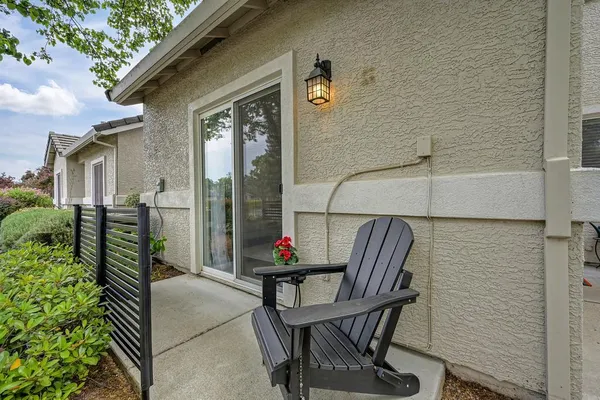 a balcony with table and chairs and potted plants