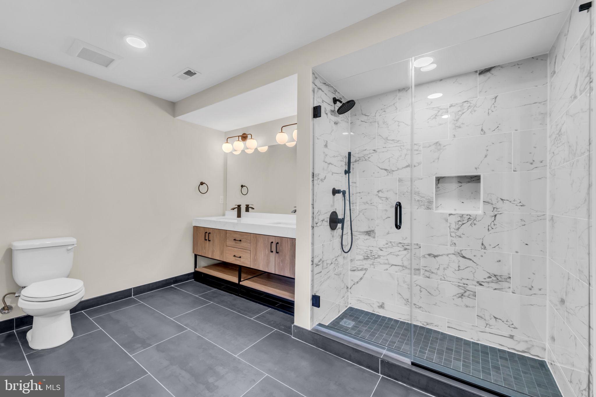 919 12th Street Northeast, Unit A303 Washington, DC 20002 - Photo 14 of 45 a bathroom with a sink a toilet and shower