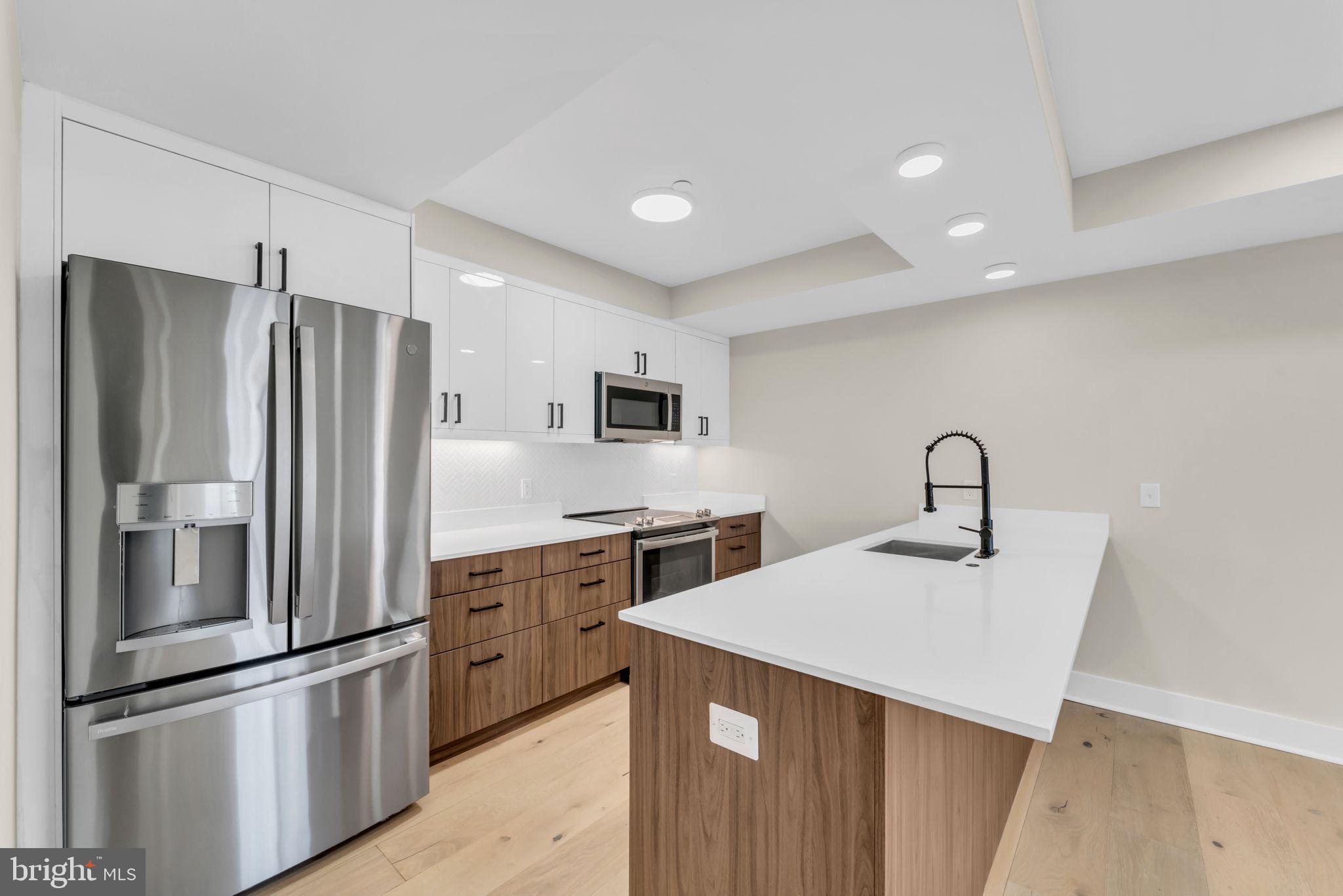919 12th Street Northeast, Unit A303 Washington, DC 20002 - Photo 2 of 45 a kitchen with stainless steel appliances a refrigerator sink and cabinets