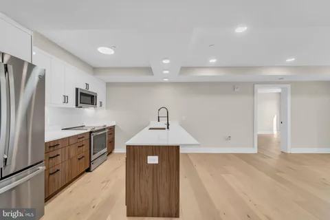 a kitchen with granite countertop a refrigerator and a sink