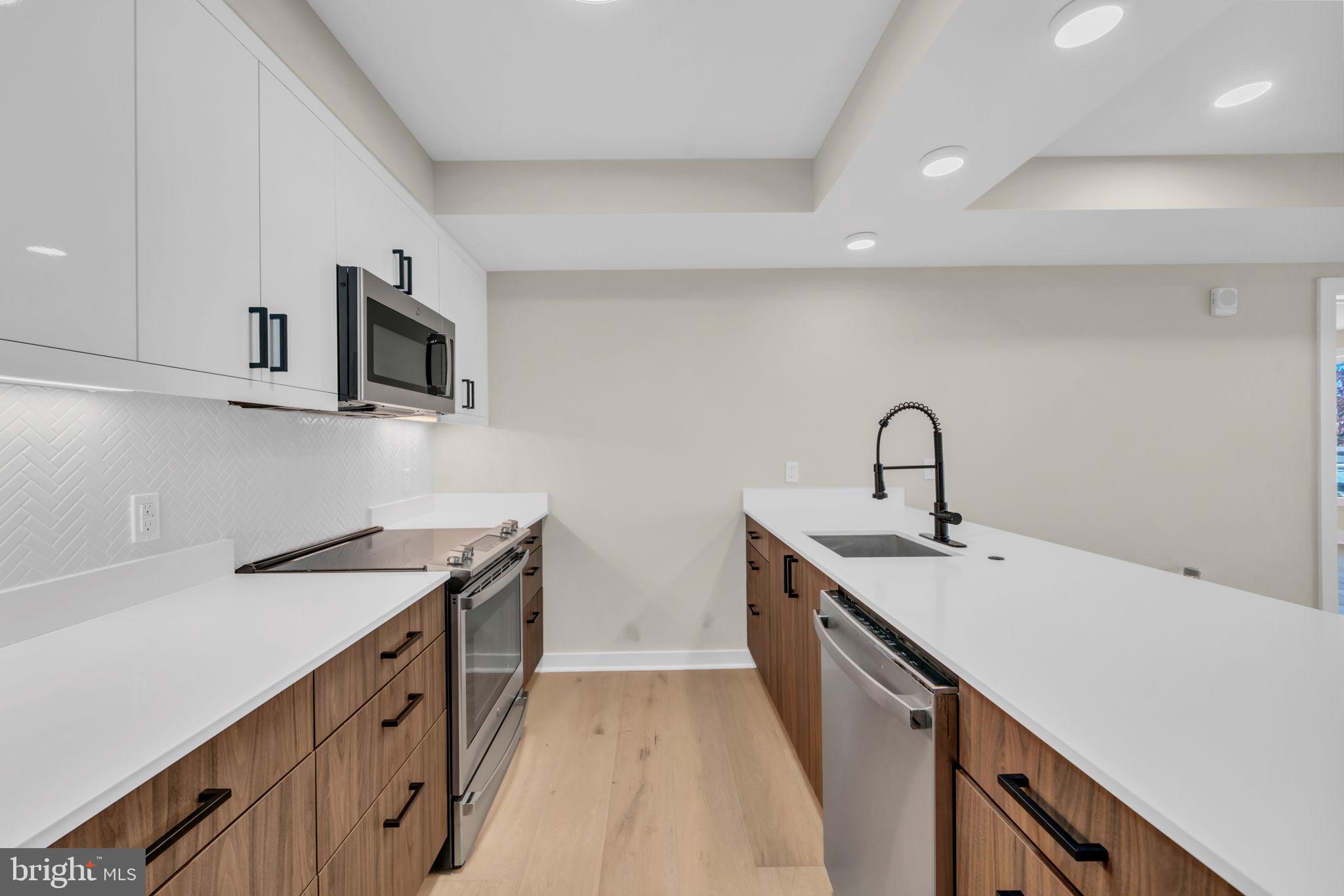 919 12th Street Northeast, Unit A303 Washington, DC 20002 - Photo 31 of 45 a kitchen with sink a microwave and stove