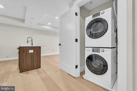 a view of a kitchen with fridge and wooden floor