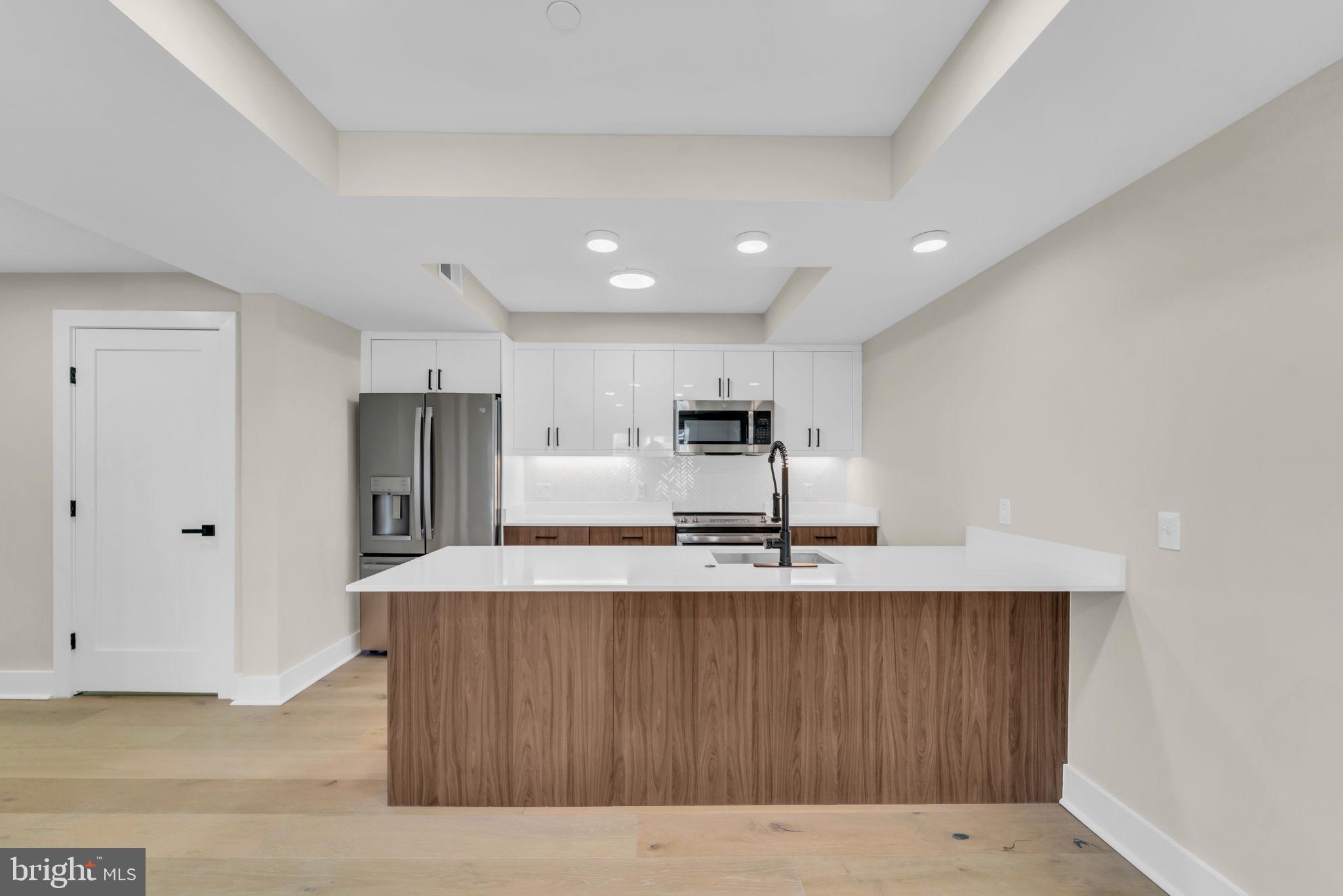 919 12th Street Northeast, Unit A303 Washington, DC 20002 - Photo 34 of 45 a large kitchen with kitchen island a sink a stove and refrigerator