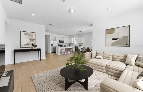 a living room with furniture and a view of kitchen