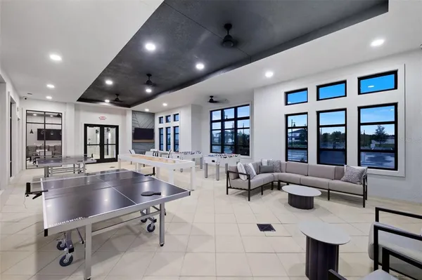 a kitchen with stainless steel appliances kitchen island granite countertop a dining table chairs and a refrigerator