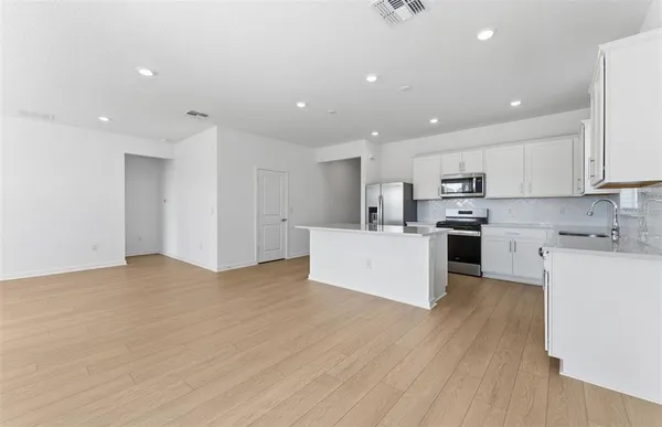a view of a kitchen with a sink and wooden floor