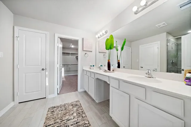 a spacious bathroom with a double vanity sink and mirror