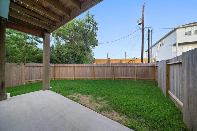 a view of a backyard with wooden fence
