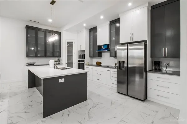 a kitchen with a refrigerator sink and cabinets