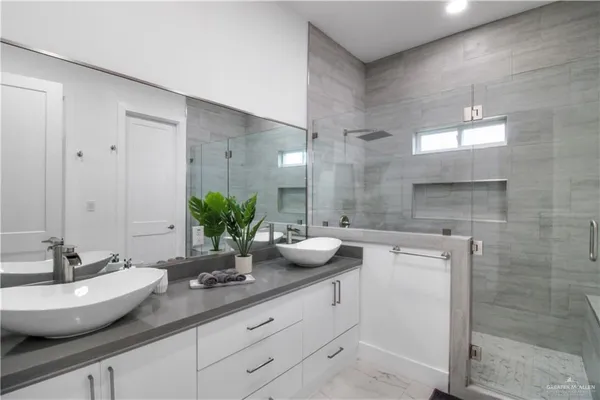 a bathroom with a granite countertop sink a large mirror and a shower
