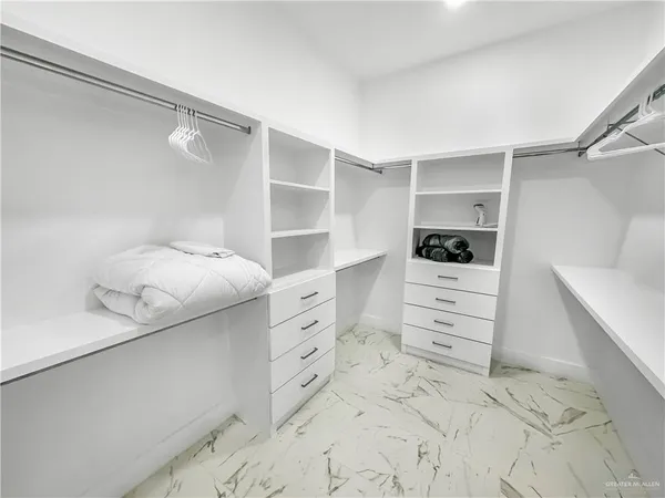 a view of walk in closet and empty room