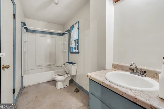 a bathroom with a granite countertop sink a toilet and a bathtub