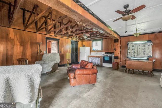a living room with furniture and a ceiling fan