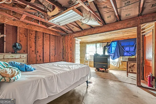 a bedroom with a bed and large windows