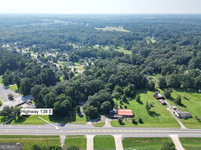 an aerial view of residential houses with outdoor space and trees