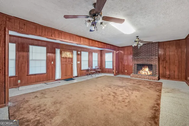 a view of an empty room with a fireplace and a window