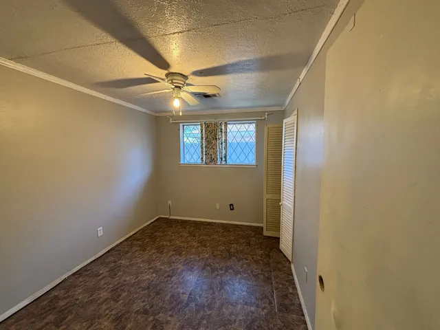 an empty room with windows and fan