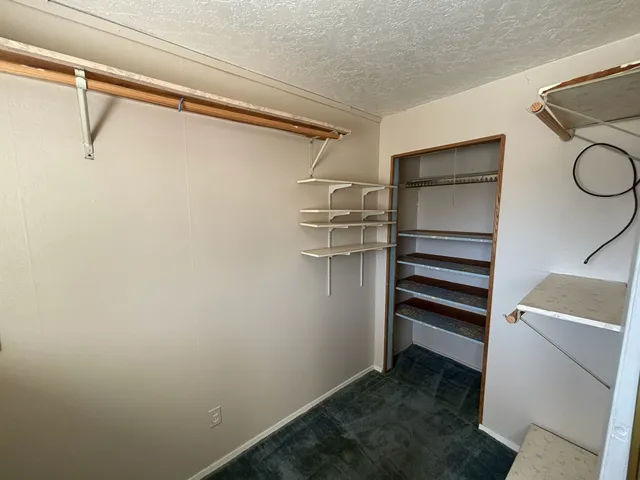 a view of walk in closet with empty racks