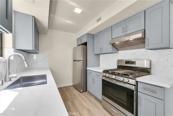 a kitchen with stainless steel appliances a stove a sink and a refrigerator