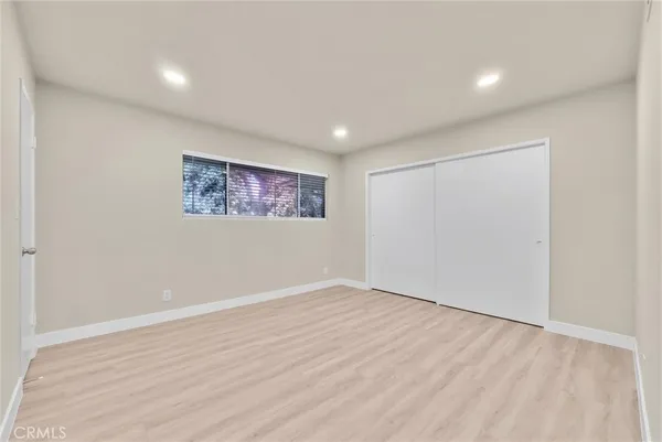 an empty room with a wooden floor and windows