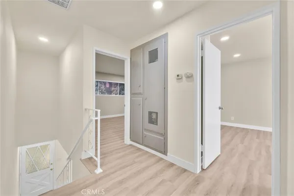 a view of a hallway with wooden floor and closet area