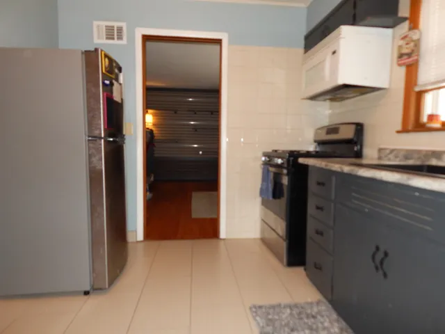 a kitchen with stainless steel appliances granite countertop a refrigerator and a stove