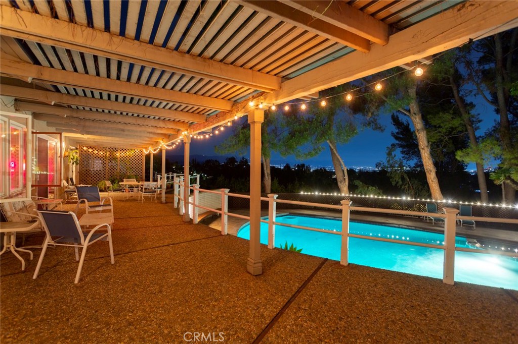 5798 Penland Road Hidden Hills, CA 91302 - Photo 9 of 13 a view of a patio with a table and chairs under an umbrella with a small yard