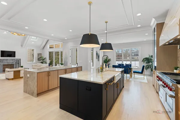 a spacious kitchen with stainless steel appliances granite countertop a sink a stove and a wooden floors