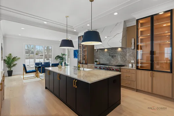 a kitchen with stainless steel appliances granite countertop a sink a stove and a wooden floors