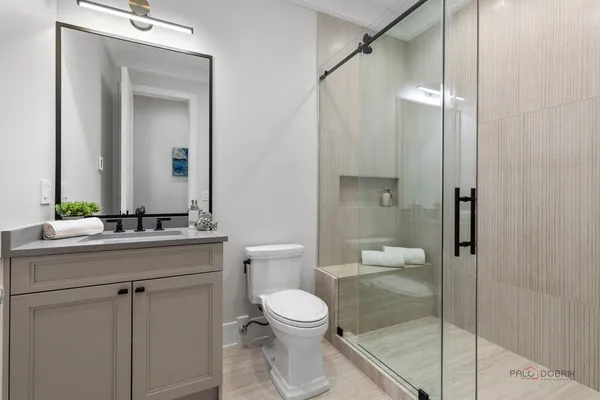 a bathroom with a toilet a sink and glass door