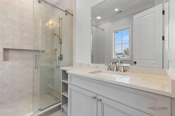 a bathroom with a granite countertop sink mirror and shower