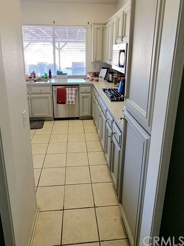 12915 Lompoc Road Apple Valley, CA 92308 - Photo 7 of 23 a large kitchen with a stove a refrigerator a sink dishwasher and wooden cabinets