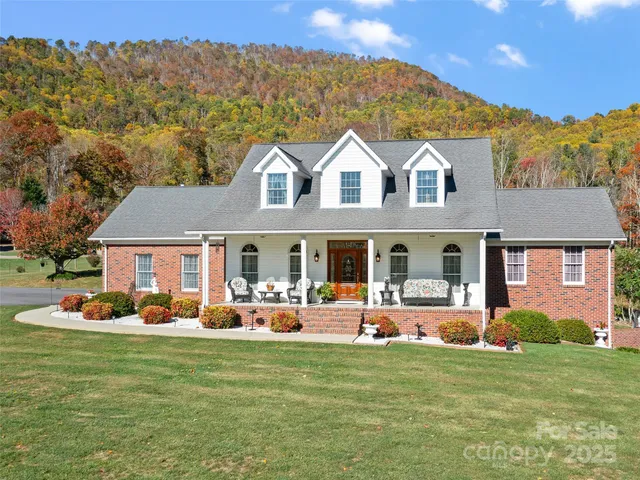 a front view of house with yard and trees in the background