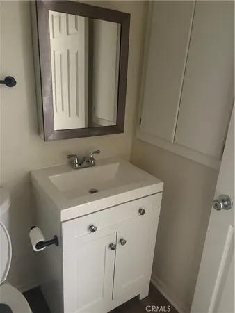 a bathroom with a sink toilet and mirror