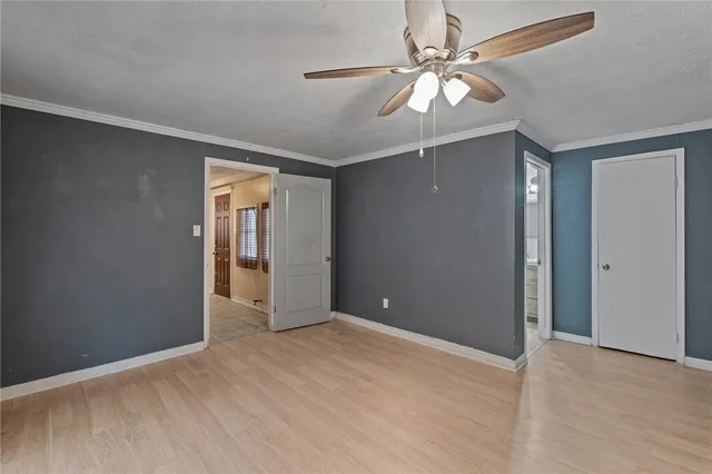 a view of an empty room with a chandelier fan