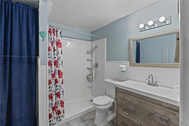 a bathroom with a toilet sink and shower curtain