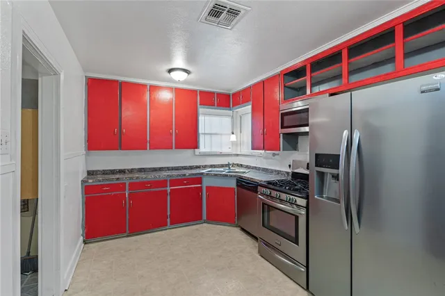 a kitchen with stainless steel appliances granite countertop a stove a sink and a refrigerator