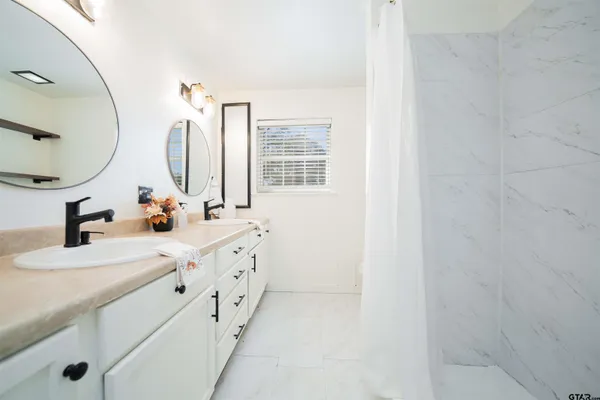 a bathroom with double vanity sink and a mirror