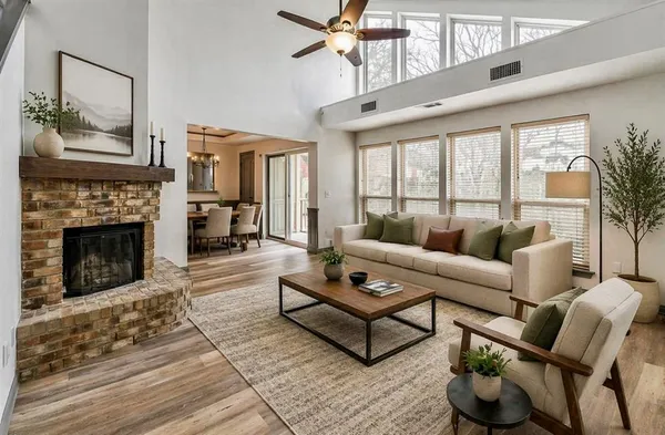 a living room with furniture a fireplace and a floor to ceiling window
