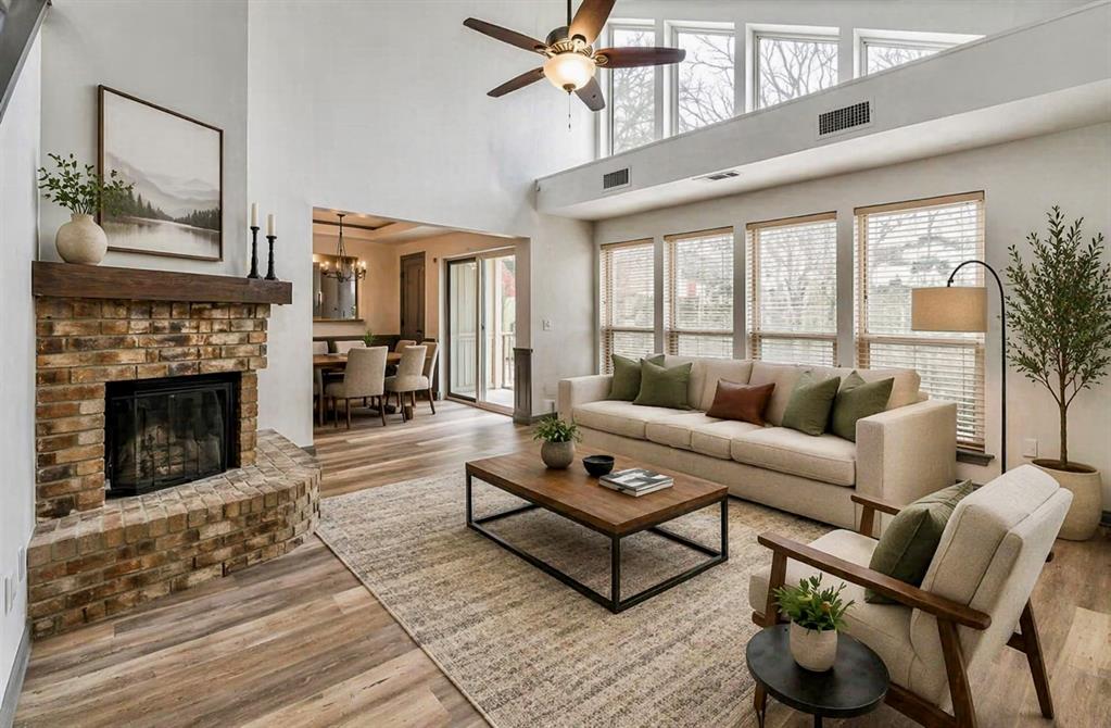 a living room with furniture a fireplace and a floor to ceiling window