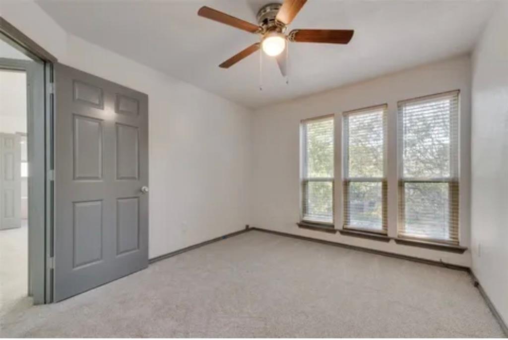 17079 Upper Bay Road Addison, TX 75001 - Photo 15 of 24 an empty room with chandelier fan and windows