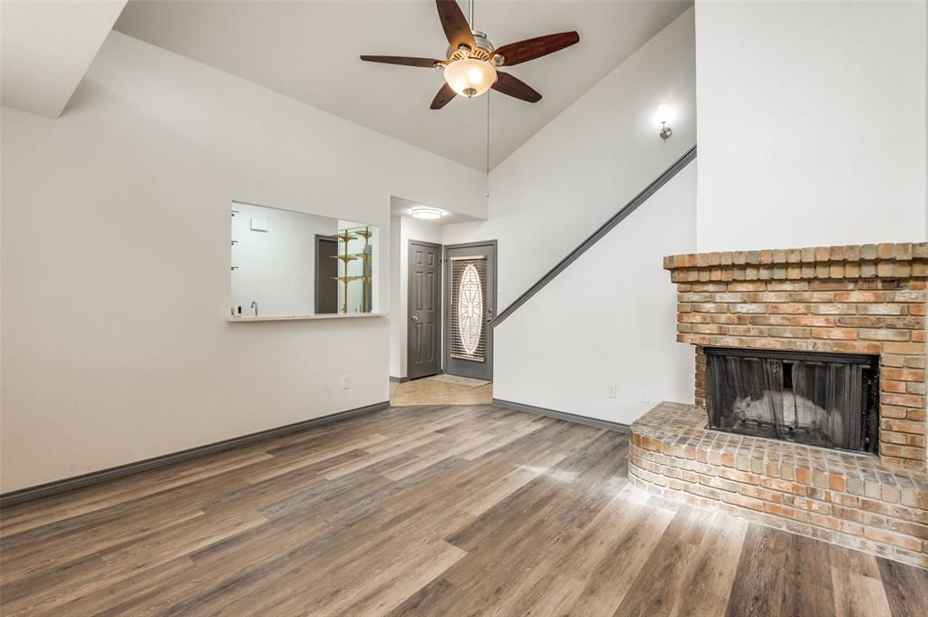 17079 Upper Bay Road Addison, TX 75001 - Photo 2 of 24 a view of empty room with wooden floor and fireplace