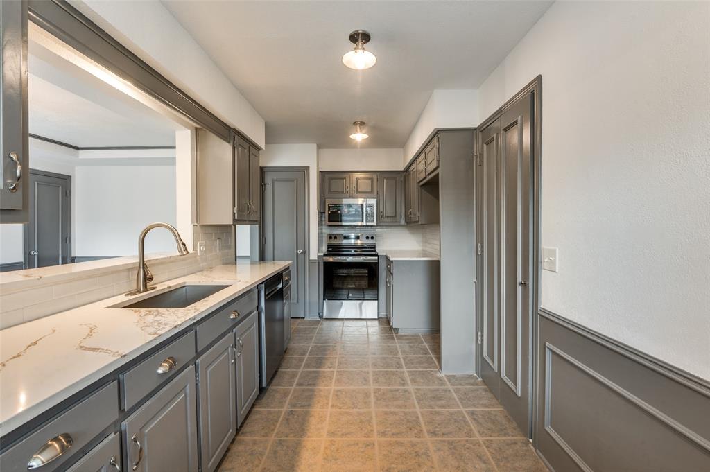 17079 Upper Bay Road Addison, TX 75001 - Photo 5 of 24 a kitchen with granite countertop a sink stainless steel appliances and cabinets