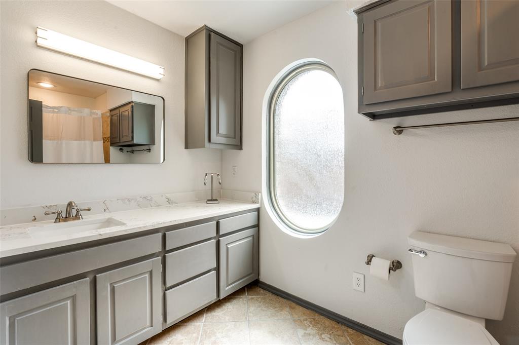 17079 Upper Bay Road Addison, TX 75001 - Photo 9 of 24 a bathroom with a toilet sink and mirror