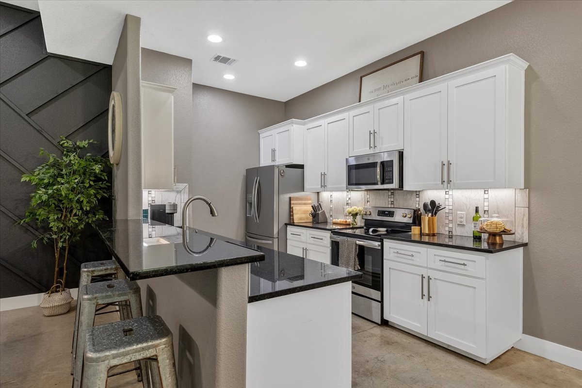 145 Cardinal Loop Paige, TX 78659 - Photo 13 of 40 Granite counters and stainless steel appliances adorn this stylish, compact kitchen.